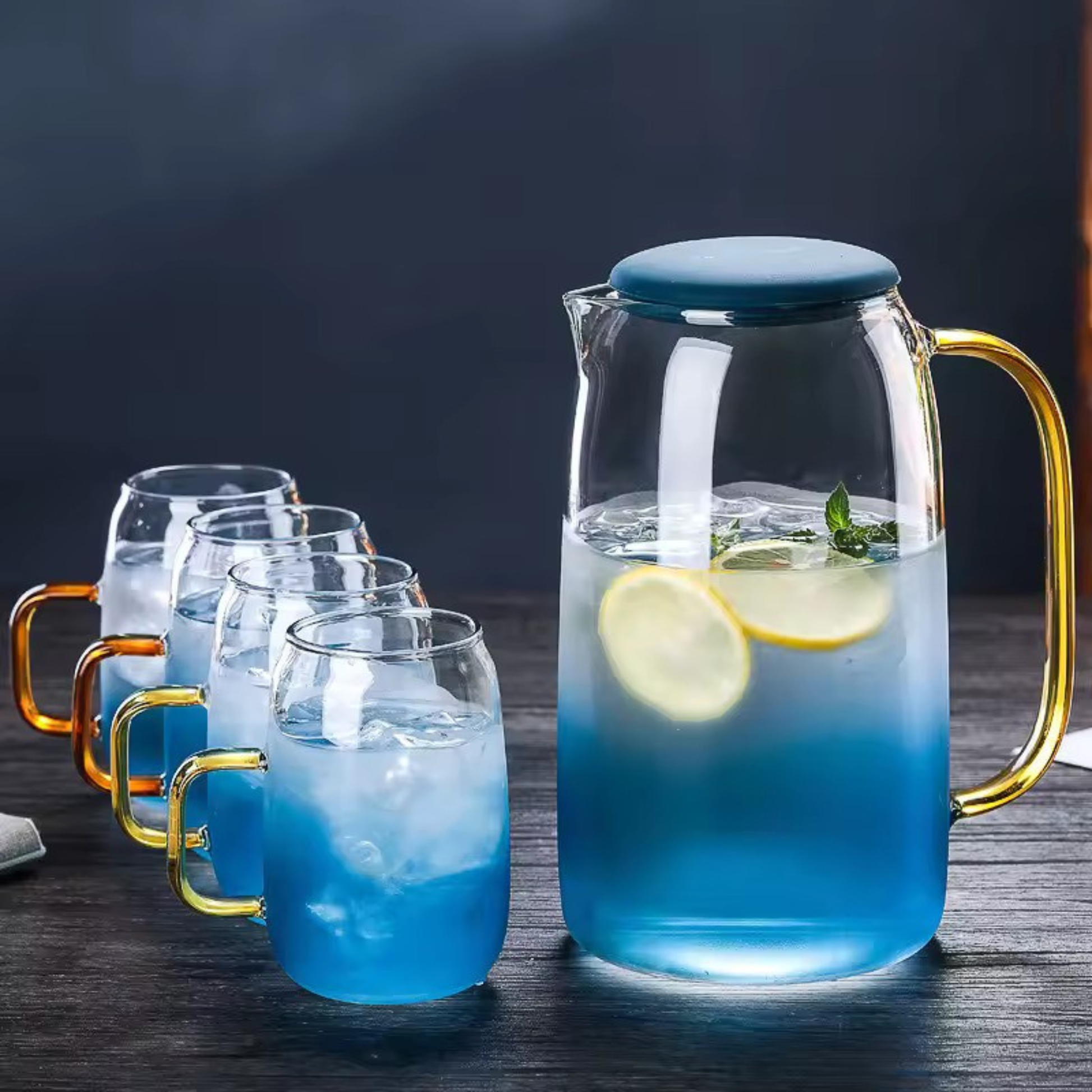 Glass water pitcher set with four cups on table